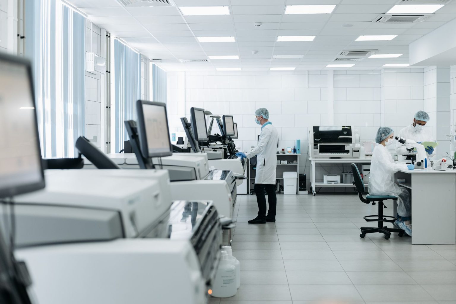 Pesquisadores trabalham em um laboratório biomédico equipado com instrumentos avançados.