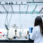 Cientista realiza pesquisas em um laboratório contemporâneo equipado com instrumentos científicos.