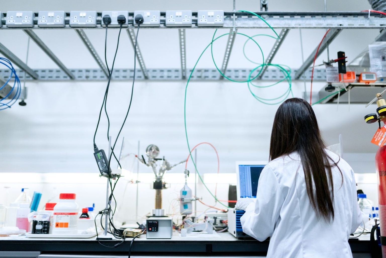 Cientista realiza pesquisas em um laboratório contemporâneo equipado com instrumentos científicos.